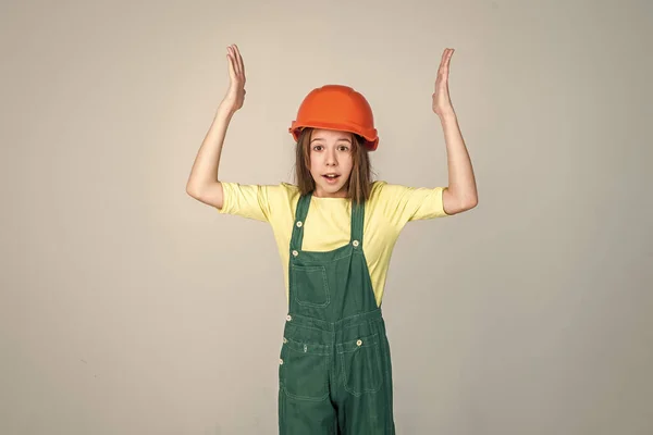 Niña usando uniforme y casco mientras trabajaba en el taller, con exceso de trabajo — Foto de Stock