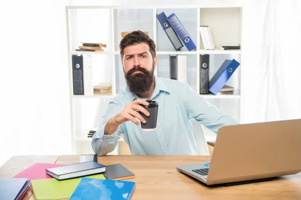 Müder professioneller Mann trinkt Kaffee zum Mitnehmen, sitzt am Schreibtisch, Kaffeepause — Stockfoto