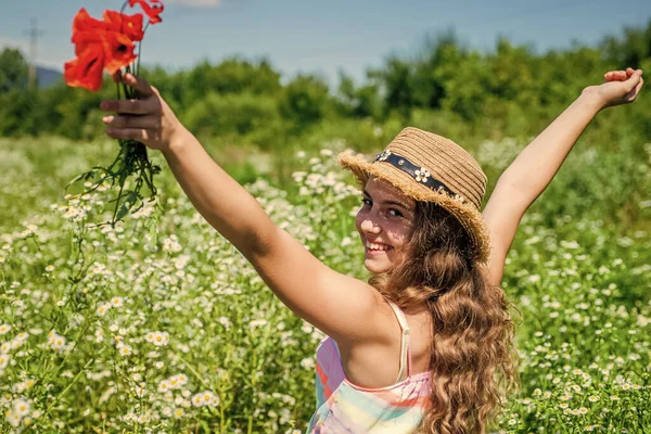 Boldog kislány gyűjtése vadvirágok napsütéses napon természet háttér, Föld nap koncepció — Stock Fotó