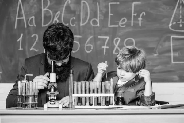 Κίνητρο εκπαίδευσης. Φιάλη στο χέρι επιστήμονα με δοκιμαστικούς σωλήνες. Αίθουσα εκπαίδευσης με μαυροπίνακα. Ο γιος και ο πατέρας στο σχολείο. Σοφία. Πίσω στο σχολείο. μικρό αγόρι με το δάσκαλο άνθρωπος — Φωτογραφία Αρχείου