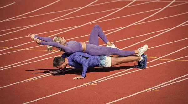 Deporte fitness hombre y mujer entrenamiento juntos de pie en tablón y empujar hacia arriba — Foto de Stock