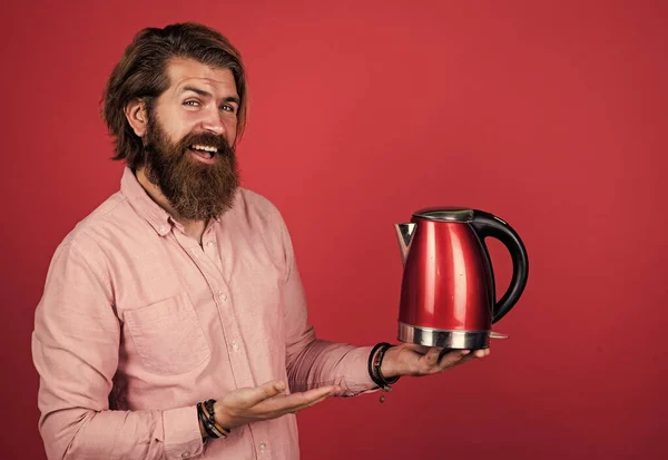 handsome bearded guy with stylish hair use electric kettle, kitchen