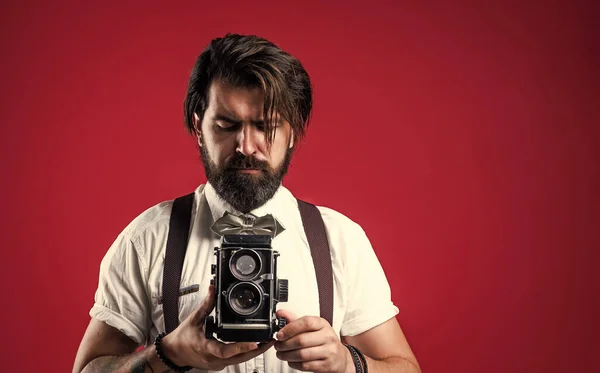 Een bebaarde man in bretels die vintage foto 's maakt. elegante zakenman houden retro camera. journalist gebruik maken van oude technologie. echte fotograaf. mannelijke schoonheid en mode. het is mijn hobby — Stockfoto