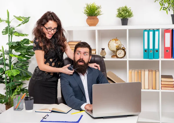 Хитрий дівчина лякає бородатого чоловіка, що ріже бороду з ножицями на робочому місці в офісі, перукар — стокове фото