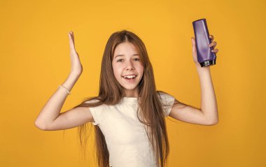 Uzun düz saçlı neşeli kız saç kremi şampuan ya da jöle şişesi, duş.