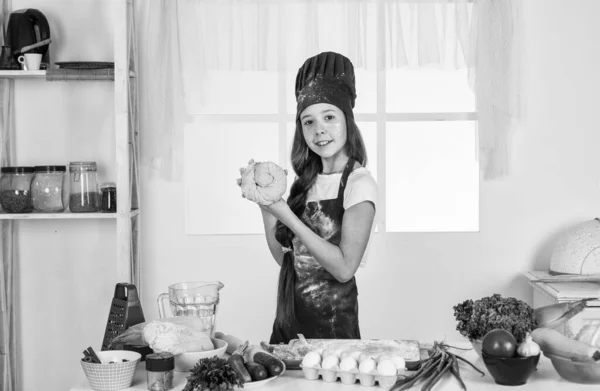 Oblíbená přísada. vývoj v dětství. Malá holka peče v kuchyni. Kuchař vaří těsto. dítě připravit zdravé jídlo doma a nosit kuchařskou uniformu. úklid a domácí práce — Stock fotografie
