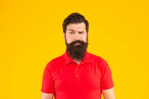 Homem barbudo grave com bigode em tshirt no fundo amarelo, cuidados com a pele — Fotografia de Stock