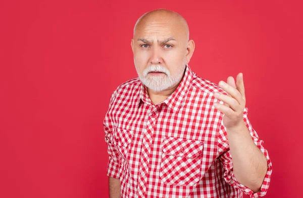 Homem sênior confuso em camisa quadriculada no fundo vermelho — Fotografia de Stock