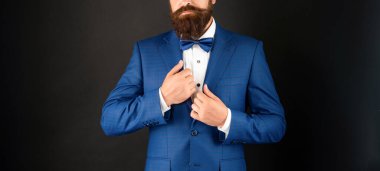 Mavi smokinli papyonlu kırpık adam. Siyah arka planda resmi giyinmiş bir beyefendi. erkek resmi moda