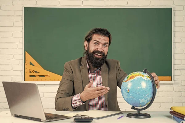 Lärare Studera geografi vid skrivbord I klassrummet med jordklotet, världskarta — Stockfoto