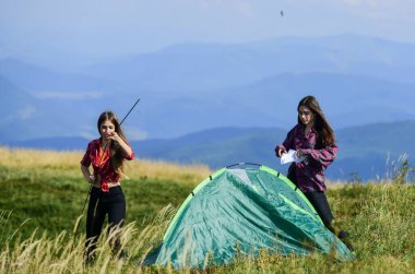 Geçici konutlar. Kamp becerileri konsepti. Kamp ve yürüyüş. Dağlarda tatil. Kamp gezisi. Çadır kuracak bir ortağın olması ne güzel. Kızlar dağın tepesine çadır kurdular. Hiçliğin ortasında