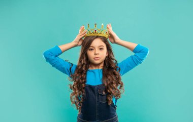 Taç giymiş bencil bir çocuk. Kendine güvenen kraliçe. Kendini beğenmişlik taslıyor. Taç içindeki kibirli prenses.