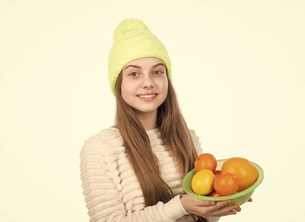 Child in hat and sweater hold citrus fruits. autumn fashion style. warm clothes. — Stock Photo, Image