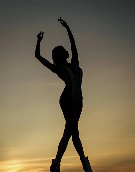 Pozycja taneczna. poczucie wolności. kobieca sylwetka po zachodzie słońca. Kobieta tańczy o wschodzie słońca — Zdjęcie stockowe