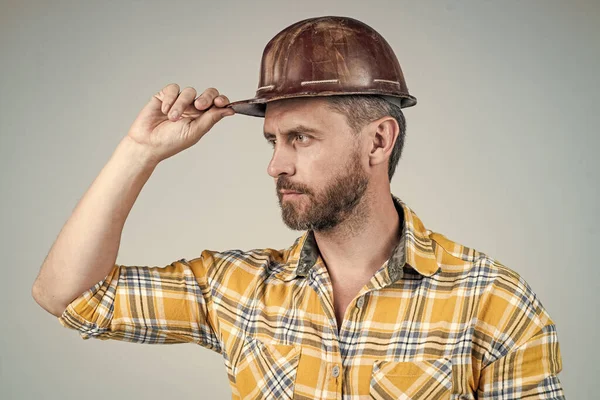 Homme architecte avec un regard sérieux. Il porte un uniforme de travailleur. beau constructeur de casque. — Photo