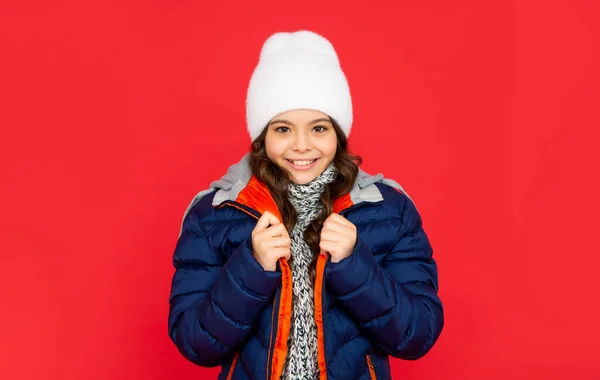 Menina bonita adolescente no fundo vermelho. retrato de criança vestindo roupas quentes com cachecol. — Fotografia de Stock