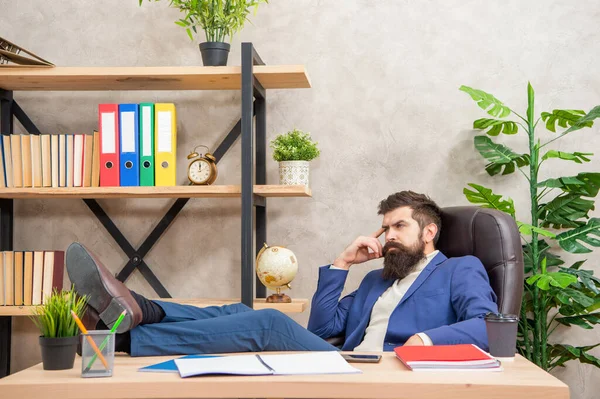 Задумчивый бизнесмен расслабляется с ногами на рабочем столе, перерыв на работе — стоковое фото