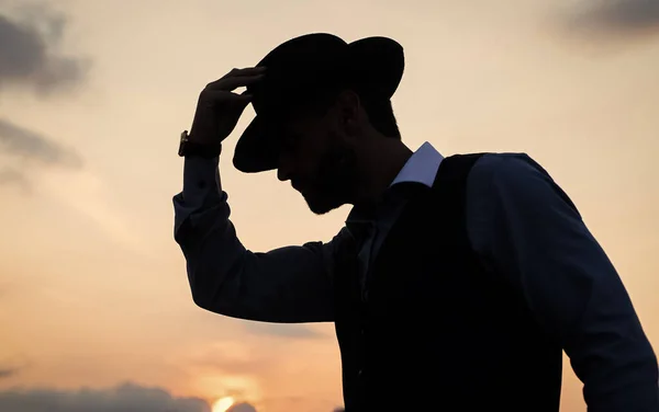 Man dancer silhouette pose with hat against sunset sky, silhouette — Stock Photo, Image