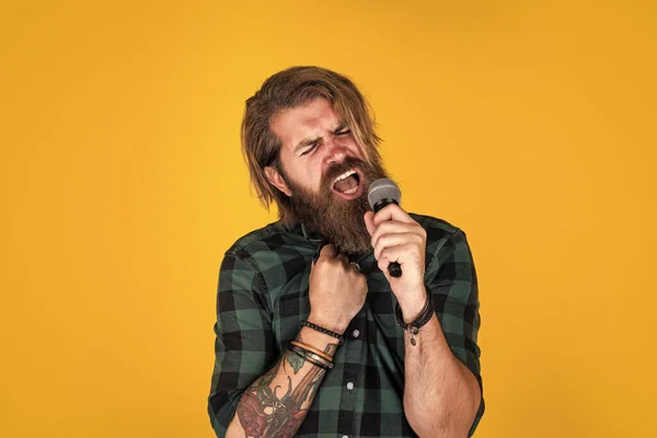 stock image mature bearded man looking casual trendy singing in microphone, music