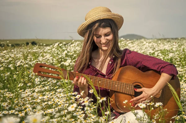 Boldog nő gyűjteni virágok nyáron százszorszép mező játszani akusztikus gitár, vidék — Stock Fotó