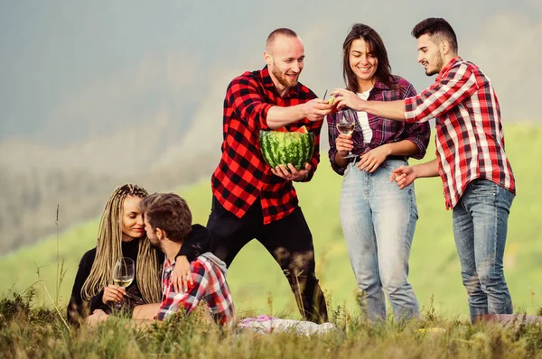 La gente que come comida bebe alcohol. Jóvenes divirtiéndose de picnic en las tierras altas. Aventuras de verano. Celebra la fiesta. Fiesta al aire libre. Grupo amigos picnic de verano. Los amigos disfrutan de vacaciones. Picnic de caminata —  Fotos de Stock