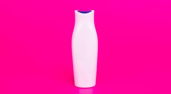Botella de champú blanco sobre fondo rosa, cosmetología — Foto de Stock