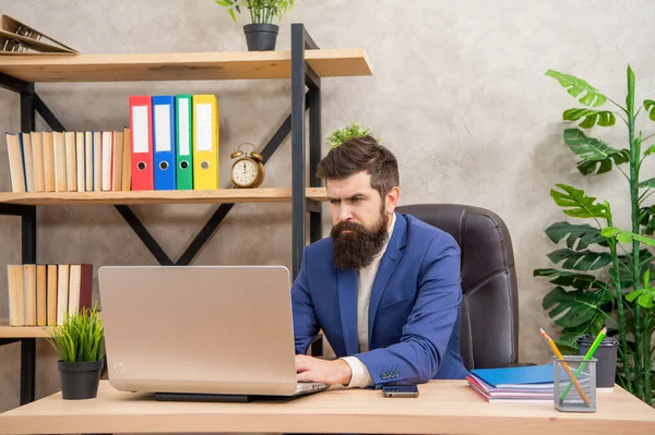 Empresario serio que trabaja en el ordenador portátil en el escritorio de la oficina, trabajo — Foto de Stock
