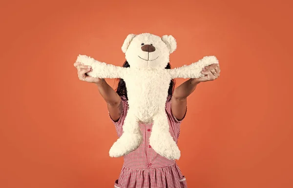 Wanita ceria bermain dengan boneka beruang mainan latar belakang oranye, toko mainan — Stok Foto