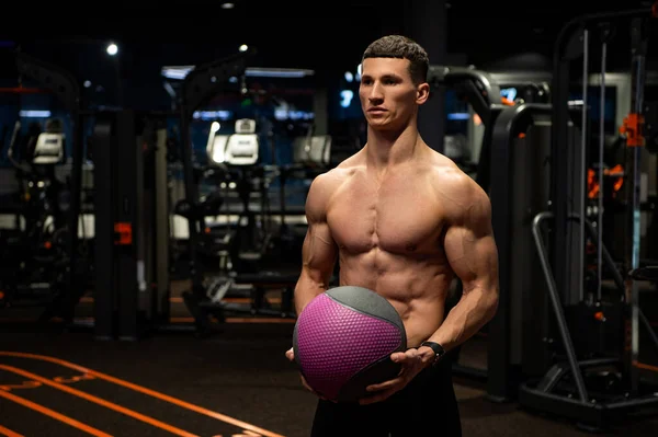 Muskelprotz mit fittem Oberkörper hält Medizinball im Fitnessstudio, Training — Stockfoto