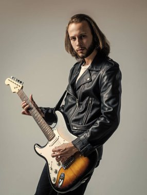 Uzun saçlı bir adam elektro gitar çalıyor. Rock müzik tarzı. müzisyen gitarist.