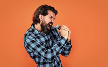 vahşi sakallı erkek şık görünümlü mikrofonla şarkı söylüyor, şarkıcı