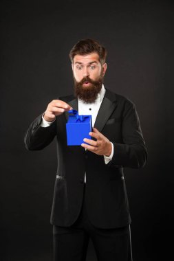 Smokinli, papyon takan, siyah arka planda, kutulu, sürpriz bir adam. Sevgililer Günü