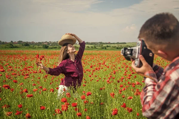 Encantados el uno con el otro. hombre y mujer fotografiando en el campo de flores de amapola. vacaciones de verano. familia feliz. primavera naturaleza belleza. amor y romance. relación romántica. pareja enamorada de la cámara —  Fotos de Stock