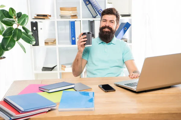 Feliz hombre de negocios sosteniendo la taza de café para llevar sentado en el escritorio de la oficina, pausa para el café —  Fotos de Stock