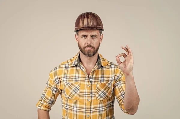 Hij draagt een arbeidersuniform. Knappe bouwer met helm. volwassen man dragen geruite shirt — Stockfoto