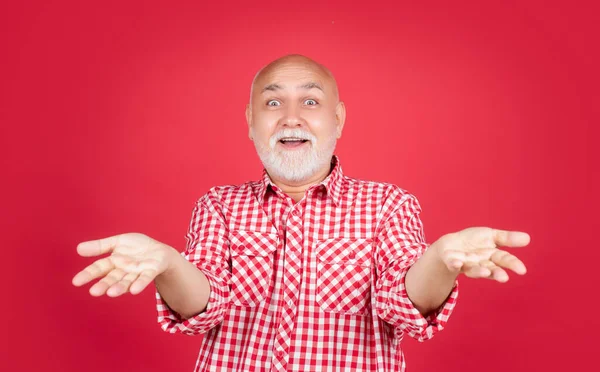 Étonné vieil homme en chemise à carreaux sur fond rouge — Photo