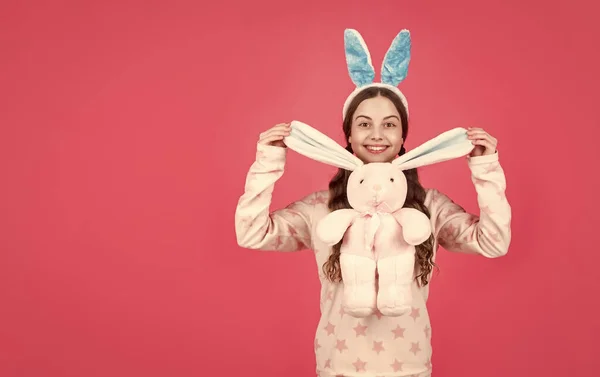 Happy easter teen girl in bunny rabbit ears and pajamas play with toy, copy space, easter — Stock Photo, Image