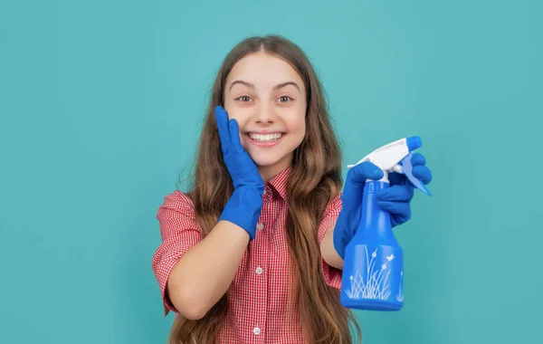 Garoto surpreso em luvas de borracha com frasco de spray no fundo azul — Fotografia de Stock