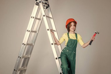 Çocuk mimar. Mühendis çekiç kullanıyor. İşçi çocuk güvenlik kaskı takıyor. İşçi Bayramı