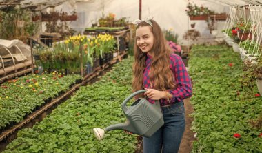 Yaz çiftliği. Bahçecilik. Çocuklar için bahçe işleri. Seradaki mutlu genç kız çiçekçi..