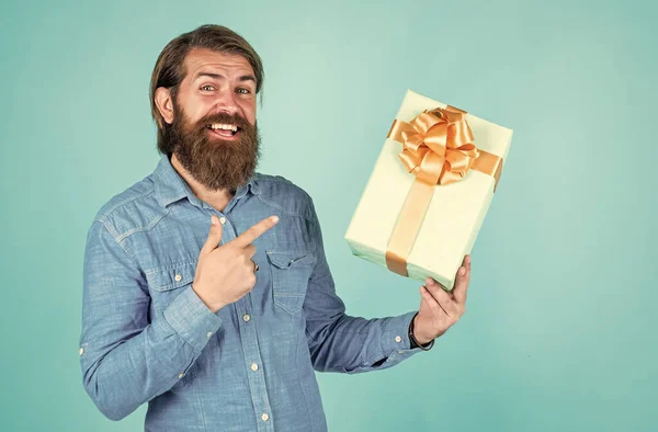 Жорстокий бородатий чоловік тримає подарунок або подарунок, свято — стокове фото
