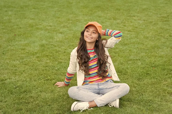 Happy school leeftijd meisje kind glimlach zitten op groen gras, kind — Stockfoto