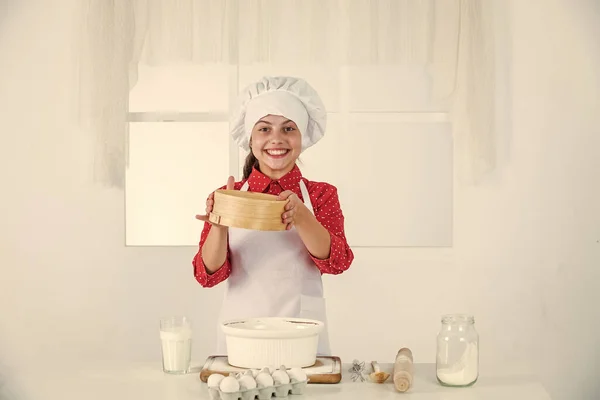 요리 모자를 쓰고 주방에서 앞치마를 두르고 빵굽는 행복 한 소녀 — 스톡 사진