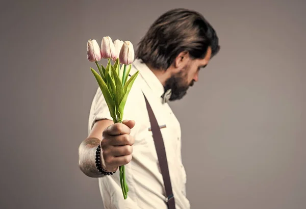 目を戻す男はバレンタインデーや誕生日のお祝いのためにチューリップの花の贈り物を運ぶ、母の日 — ストック写真