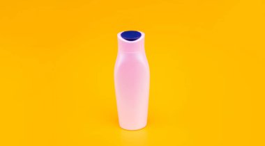 Sarı arka planda beyaz şampuan şişesi, güzellik ürünü.