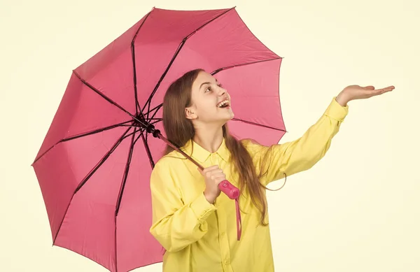 Feliz chica elegante captura gota de lluvia aislado en blanco. alegre adolescente niño hold rosa parasol. —  Fotos de Stock