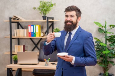 Neşeli sakallı iş adamı ofiste fotokopi odası ve kahve molası ile kahve içiyor.