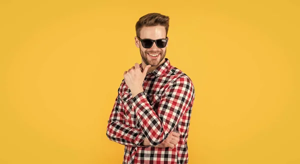 Stylischer Typ mit trendiger Frisur trägt kariertes Hemd und Brille, Kleiderschrank — Stockfoto