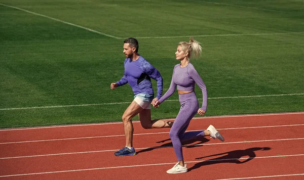 Equipe casal esporte em sportswear correr no estádio, competição — Fotografia de Stock
