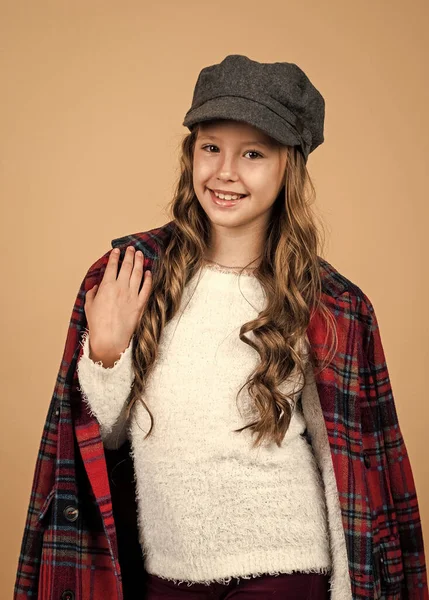 Teen dívka s dlouhými kudrnatými vlasy nosit módní klobouk a kostkované sako, francouzská móda — Stock fotografie